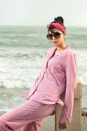 The Coral Pink Cozy Button Down Shirt for Women pairs a relaxed-fit top with soft pajama bottoms for all-night comfort.