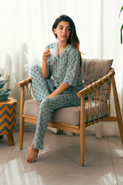 The Palm Oasis Women's Button Down Shirt Pajama Set includes a relaxed-fit top and matching pants for a classic sleepwear look.